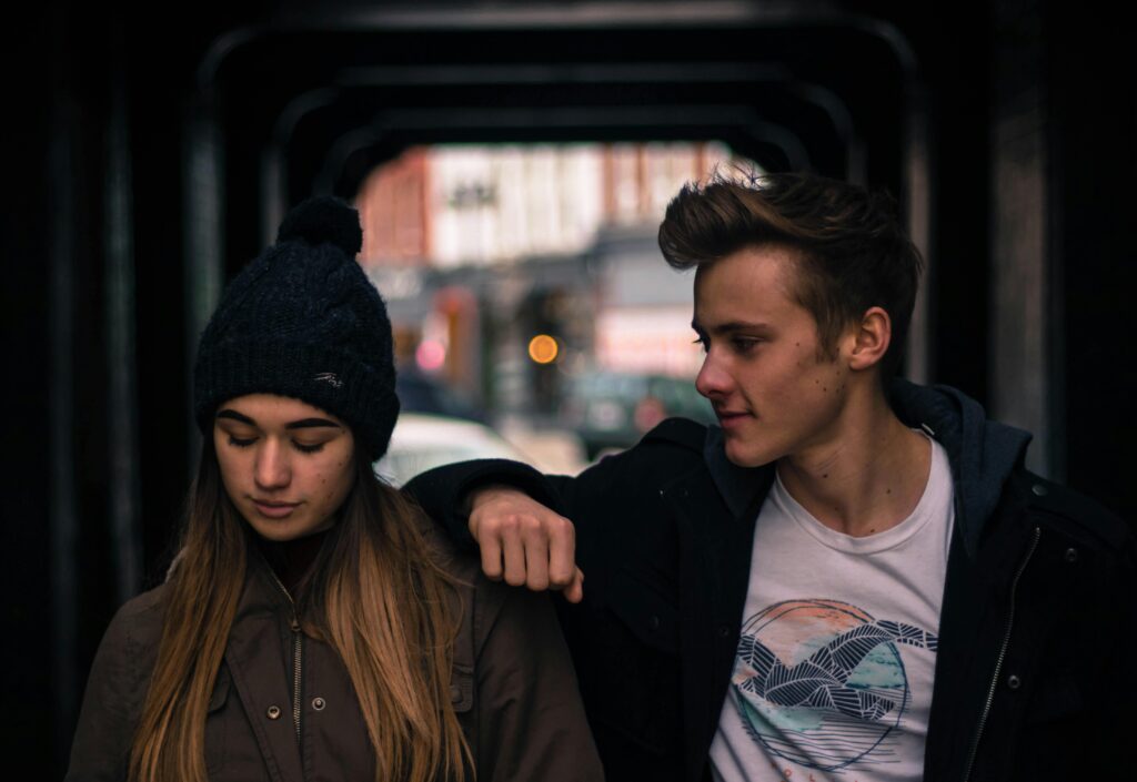 Man trying to comfort his girlfriend while walking. 